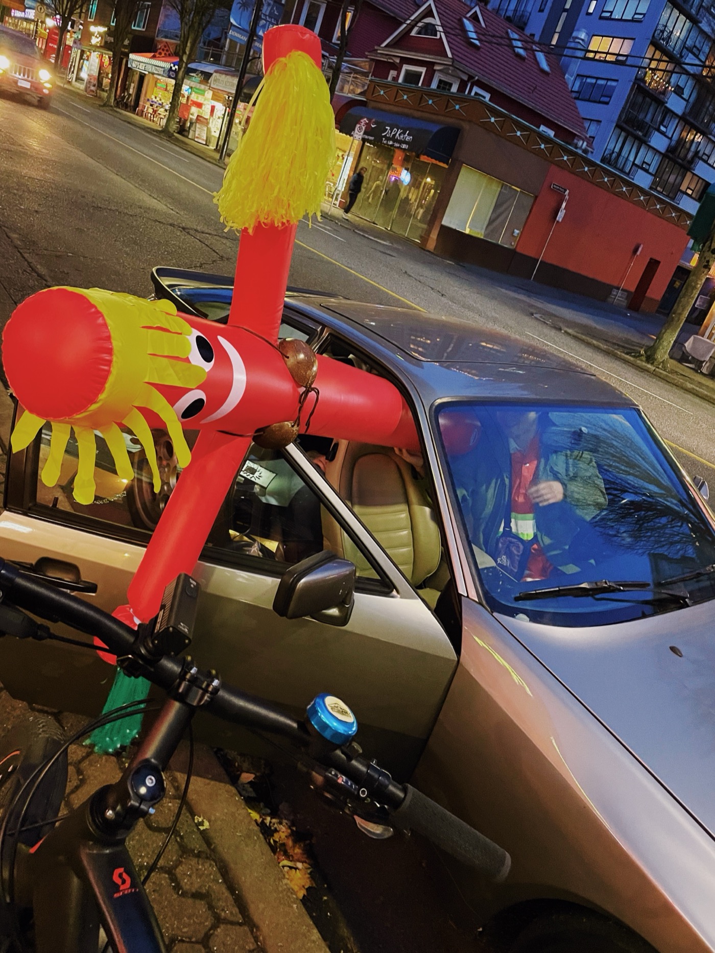 Inflatable tube man strapped to a bike at night